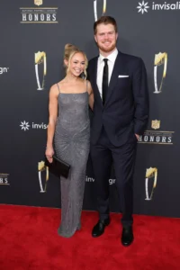 **Alt Text (SEO Optimized with Keyword):** *Sam Darnold and fiance Katie Hoofnagle pose together on the red carpet at the NFL Honors event, wearing formal evening attire and smiling for photographers.*