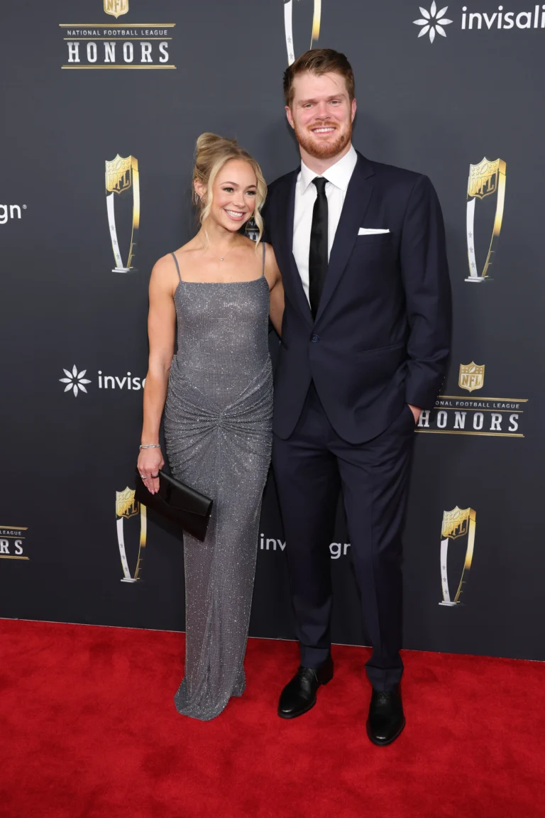 **Alt Text (SEO Optimized with Keyword):** *Sam Darnold and fiance Katie Hoofnagle pose together on the red carpet at the NFL Honors event, wearing formal evening attire and smiling for photographers.*