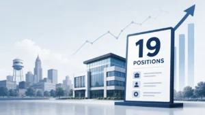 Professional business news illustration showing a modern Albert Lea city skyline, a corporate office building, and a large hiring board displaying 19 positions. An upward growth chart in the background symbolizes job growth, economic development, and new employment opportunities in Albert Lea. Clean blue and gray corporate design with a minimalist editorial style.